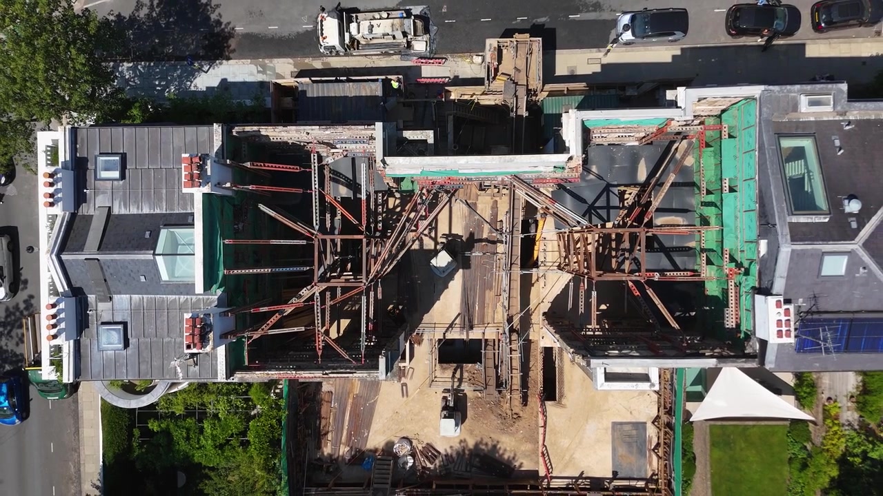 Top down view of steel props and shoring bracing the open shell of a prime townhouse during a deep basement excavation
