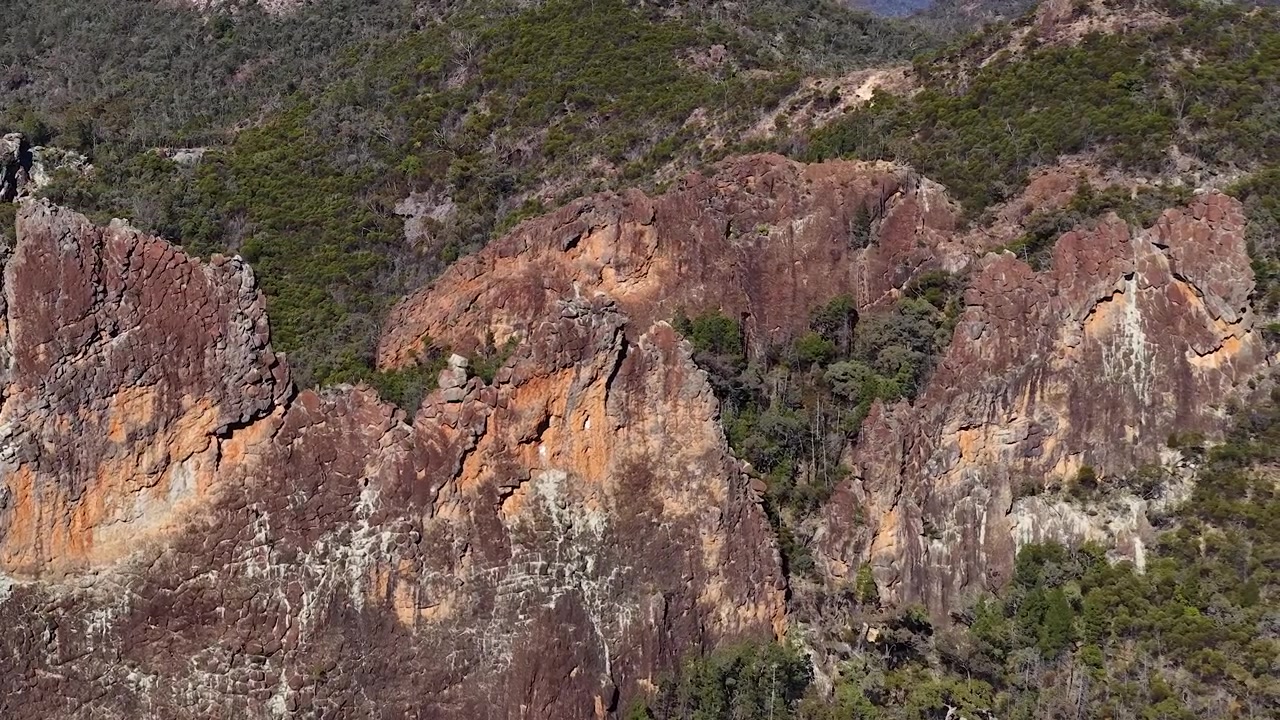Inquadratura ampia statica di pareti e creste di roccia vulcanica nel Parco Nazionale Warrumbungle, Australia