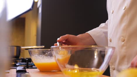 el chef comprueba la consistencia de la masa en un bol