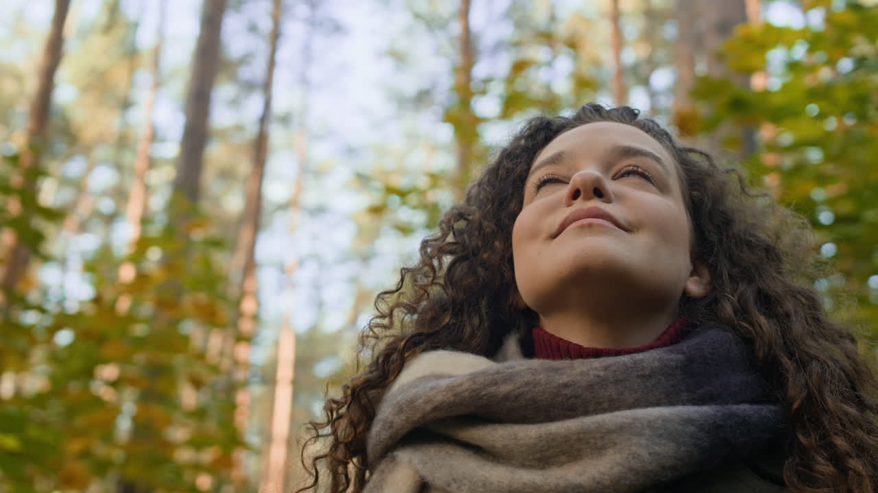 Woman looking up in autumn forest