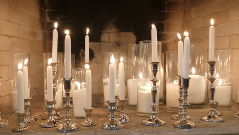 candles and candlesticks in fireplace