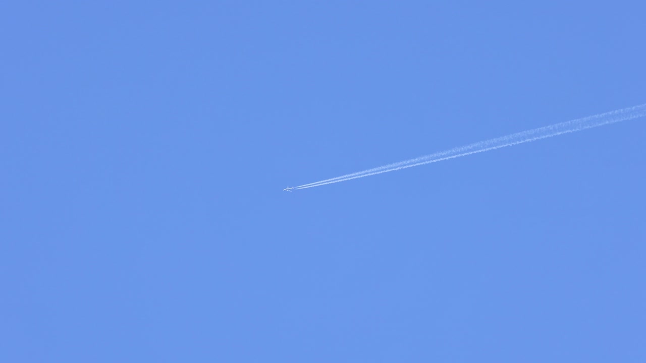 은 파란 하늘에서 콘트레일을 떠나는 비행기