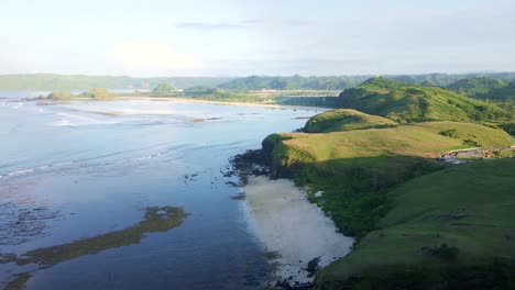 Wide-shot-drone-footage-captures-the-breathtaking-expanse-of-the-exotic-ocean-from-the-hillside-of-Bukit-Merese,-on-Lombok-Island,-in-the-morning