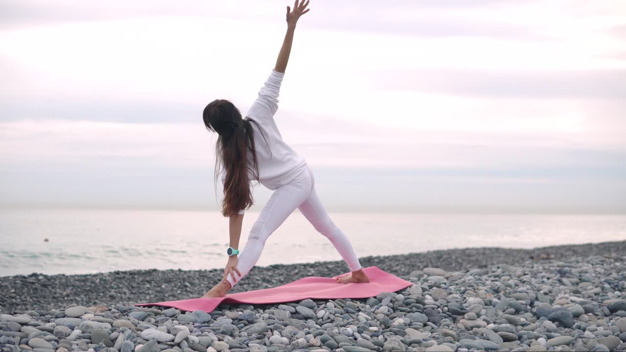 해변 에서 요가 를 연습 하는 여자