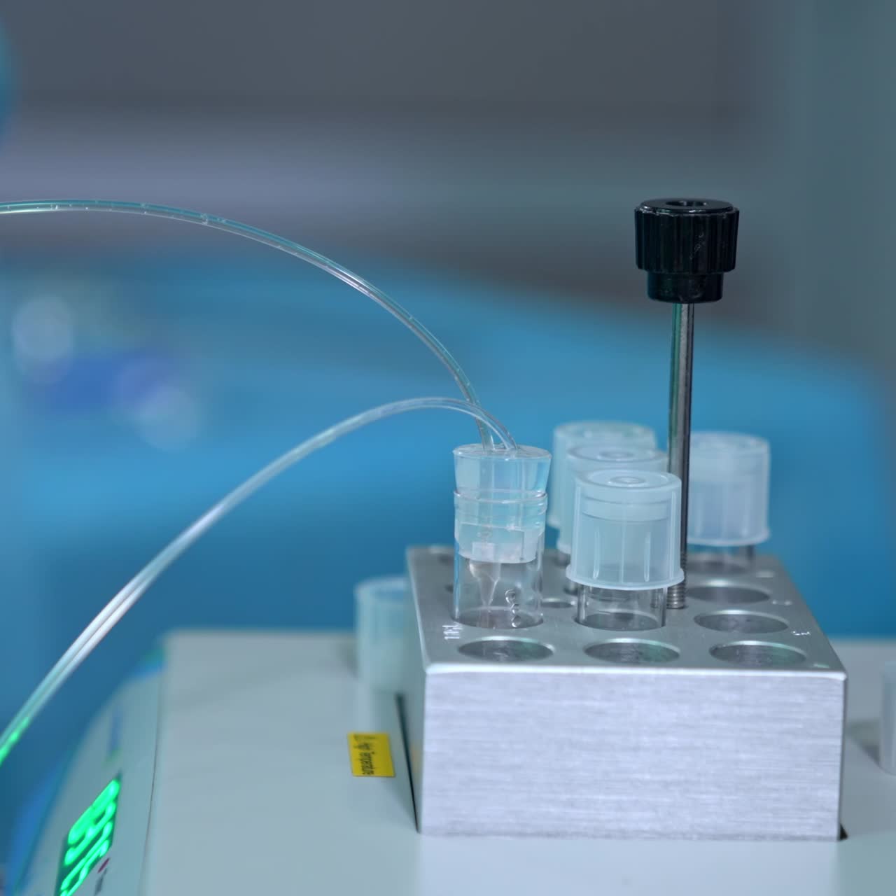 A set of little reservoirs in the laboratory. Test tube is filled with liquid through the thin tube. Close up. Blurred backdrop