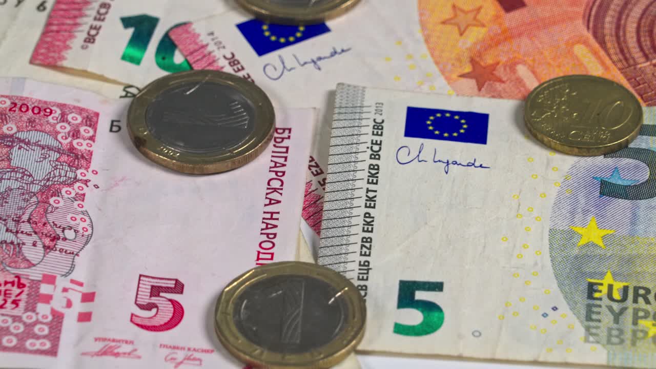 Multiple euro banknotes and coins displayed on a flat surface