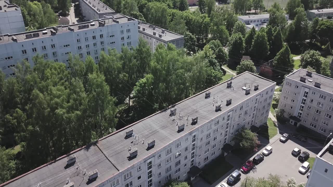 Aerial drone footage of blockhouses, trees, and cars in typical eastern Europe neighborhood