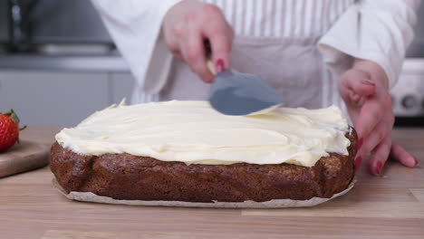 Frischkäse-Frosting-Auf-Frisch-Gebackenem-Karottenkuchen-In-Der-Küche-Verteilen