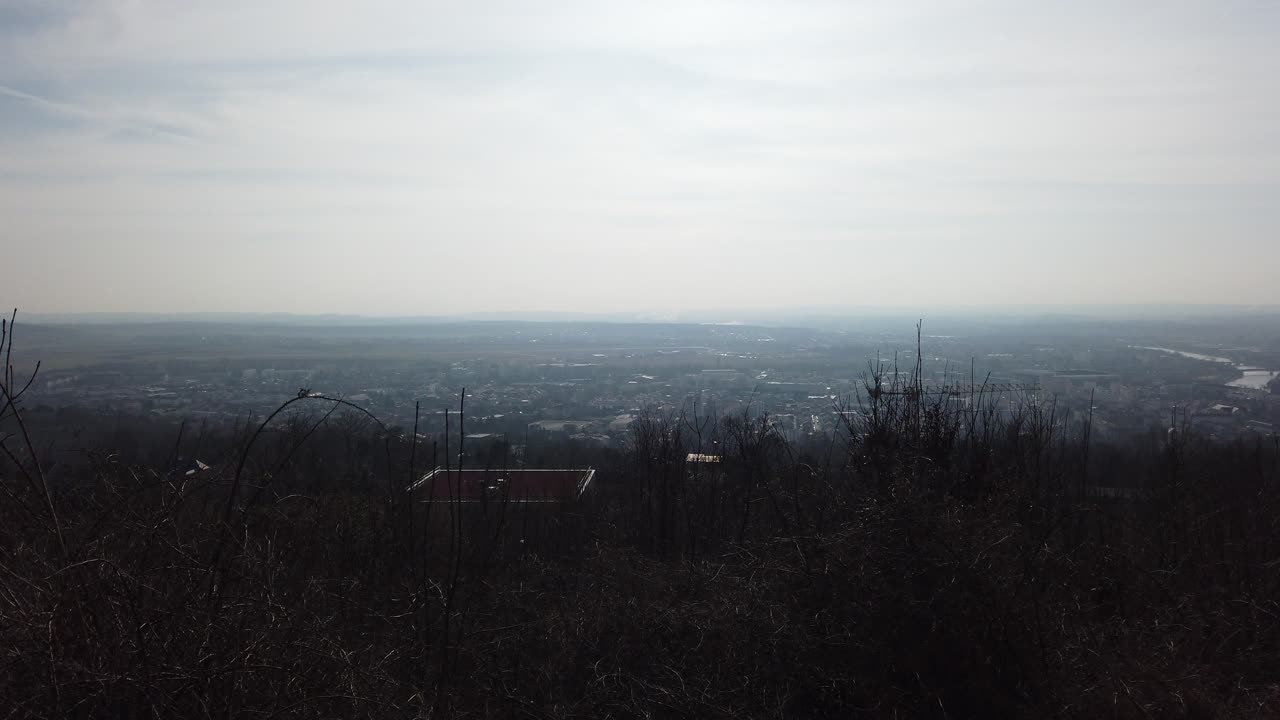 A serene panoramic view from Plateau de Malzéville, showcasing the expansive landscape below, with a mix of natural and urban elements visible in the distance.