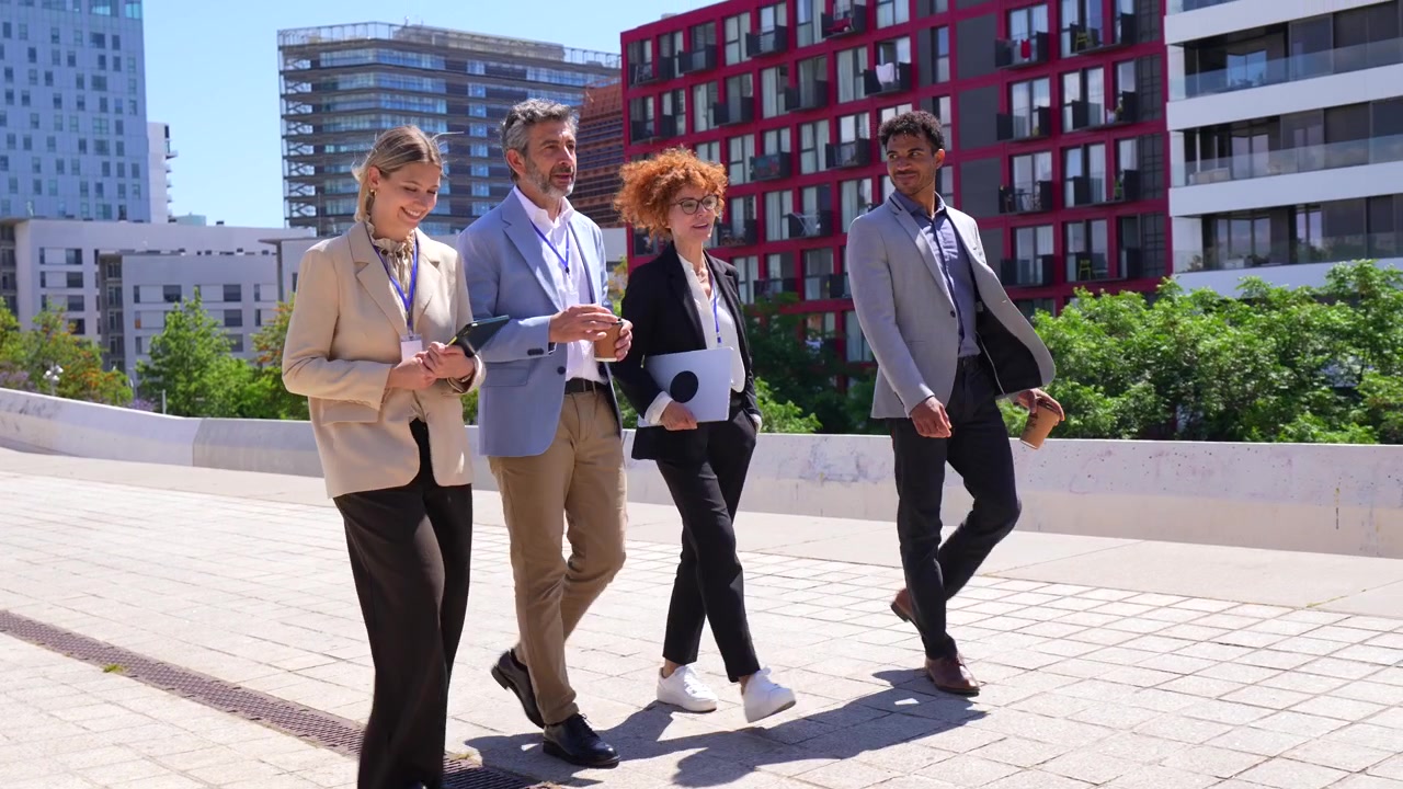 Divers zakelijk team wandelt en overlegt buiten in een moderne stad
