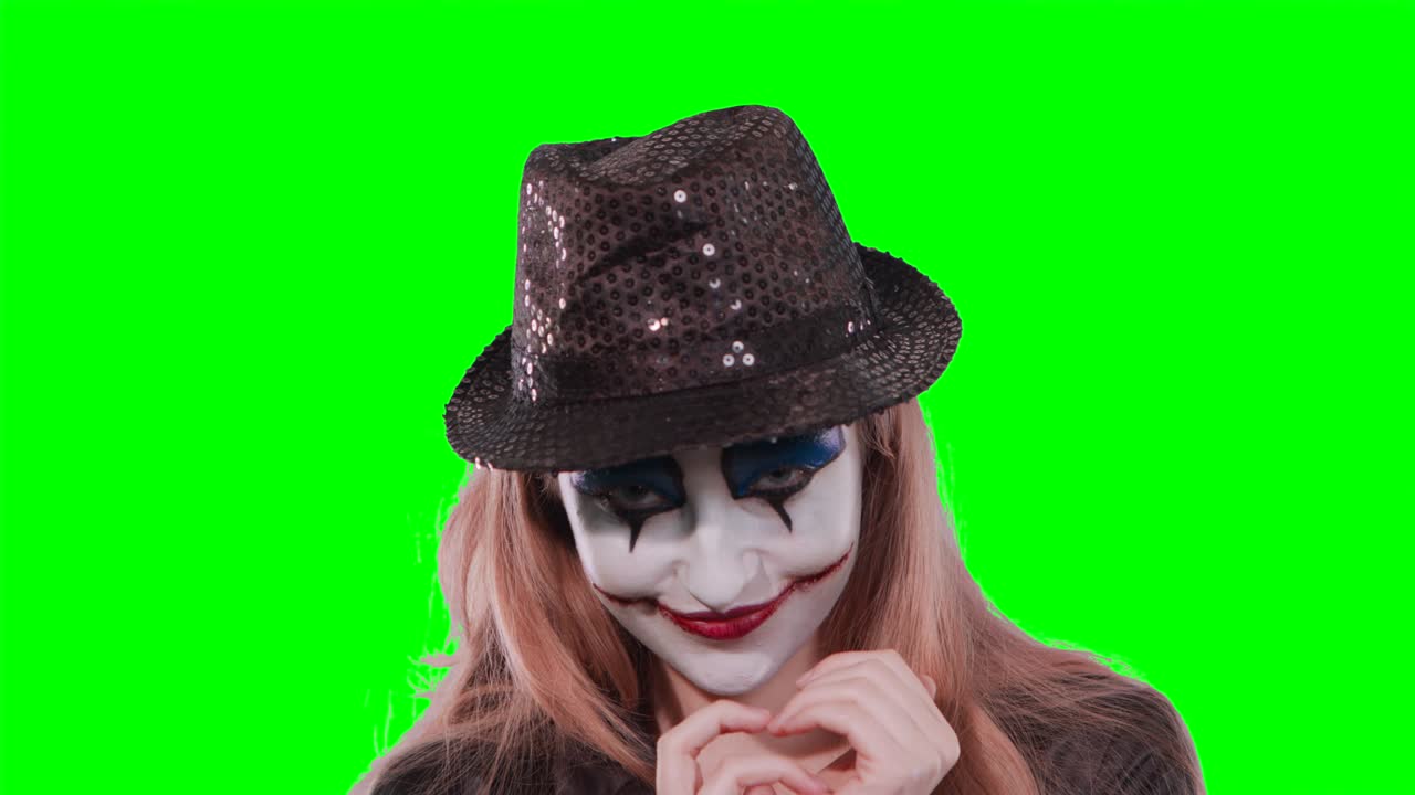 la muchacha payaso frota los dedos y sonríe,