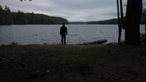 Male-figure-standing-on-the-shoreline-at-MacDonald-Lake