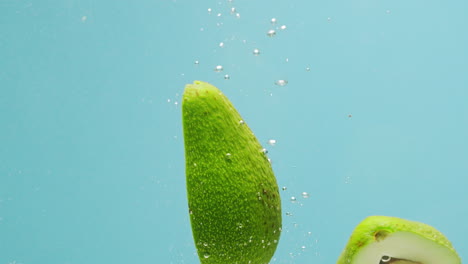 avocado slices splashing underwater