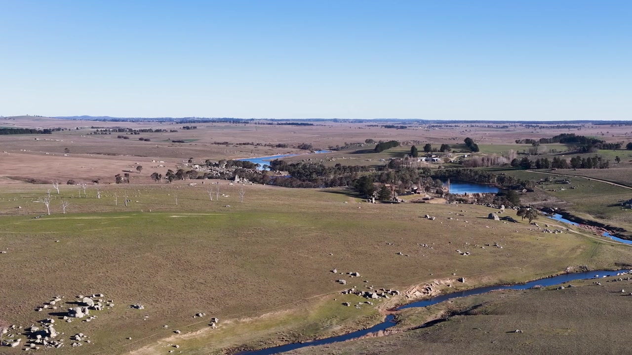 Ampia ripresa aerea di un fiume che scorre attraverso dolci colline verdi a Uralla, Australia