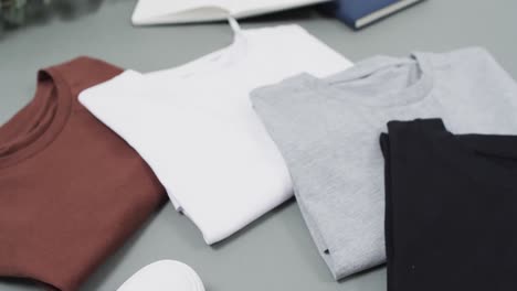 Video-of-flat-lay-of-t-shirts-with-copy-space-on-grey-background