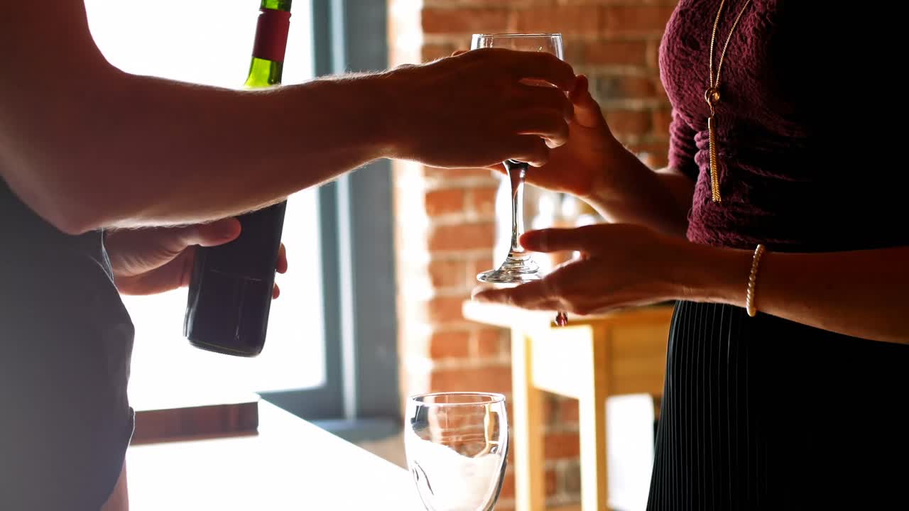 Mid section of couple having red wine