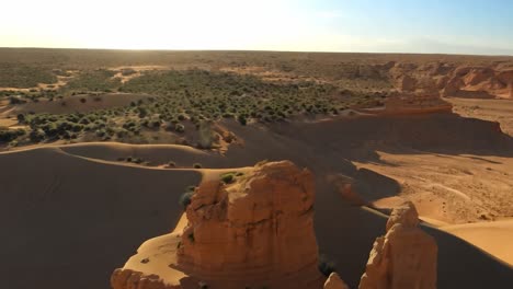 aerial view of a desert canyon with sand dunes and rock formations