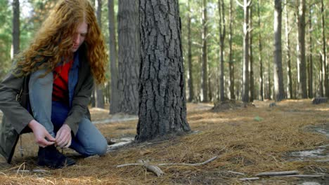 woman tying shoe laces in the forest 4k