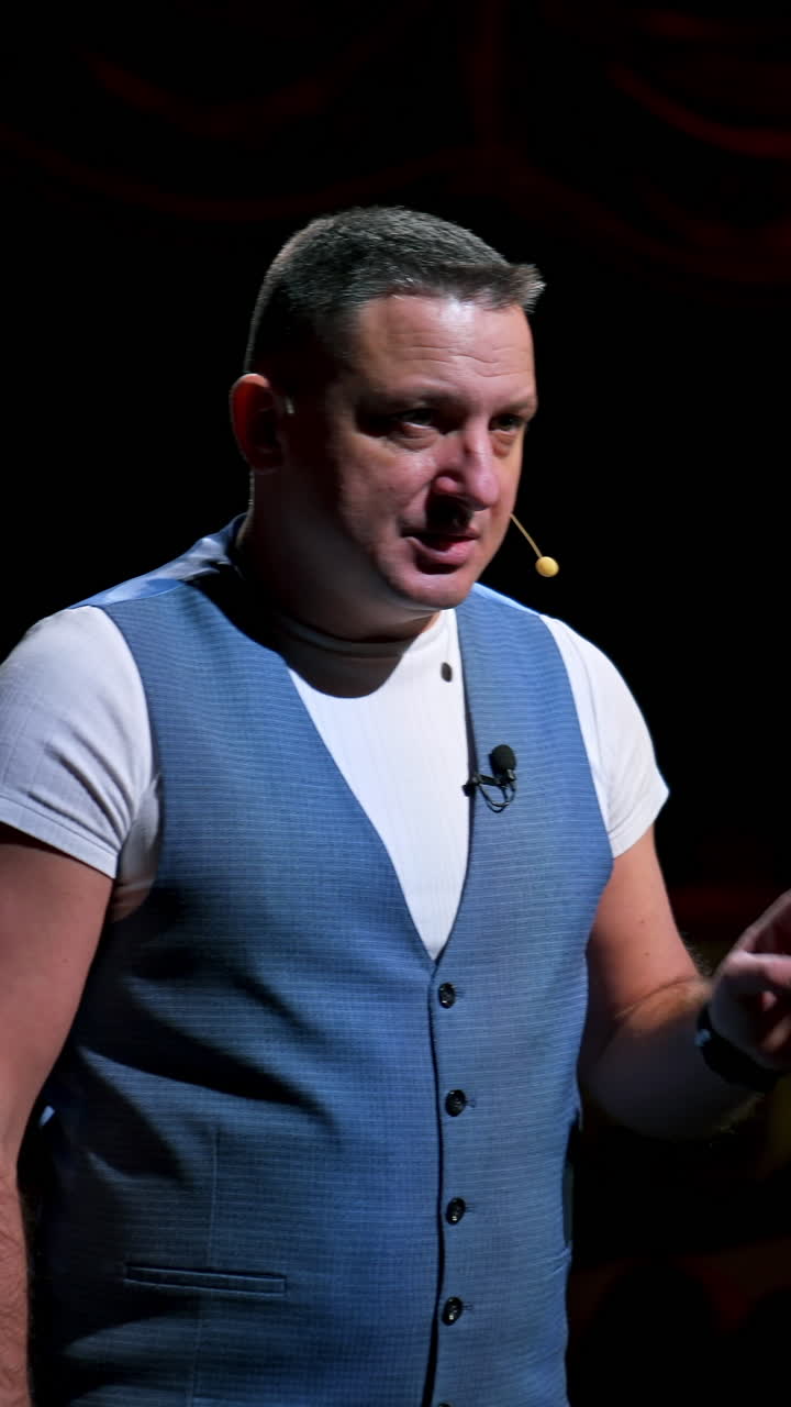 Actor on classic theatre stage. Man is speaking in spotlights during the performance. Side view video. Vertical video