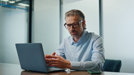 Happy-businessman-computer-videocalling-cabinet-close-up.-Smiling-boss-talking