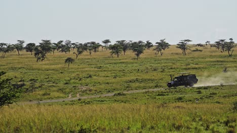 slow motion shot of four wheel drive jeep driving across the plain on dustry road track, african wildlife in maasai mara national reserve, kenya, africa safari animals in masai mara north conservancy