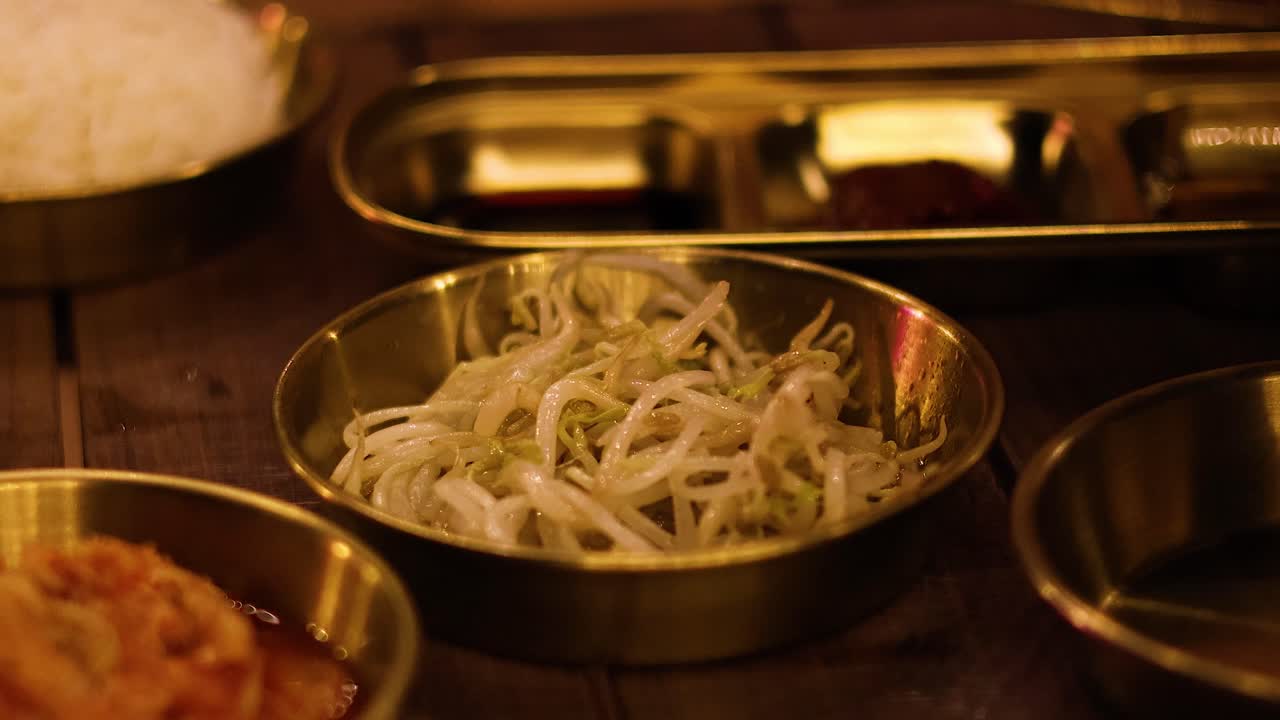 Chopsticks lifting mung bean sprouts from bowl