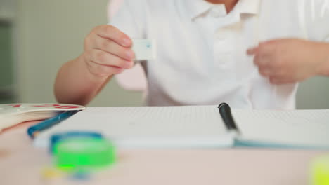niño pequeño mira y limpia la imagen con borrador en el cuaderno