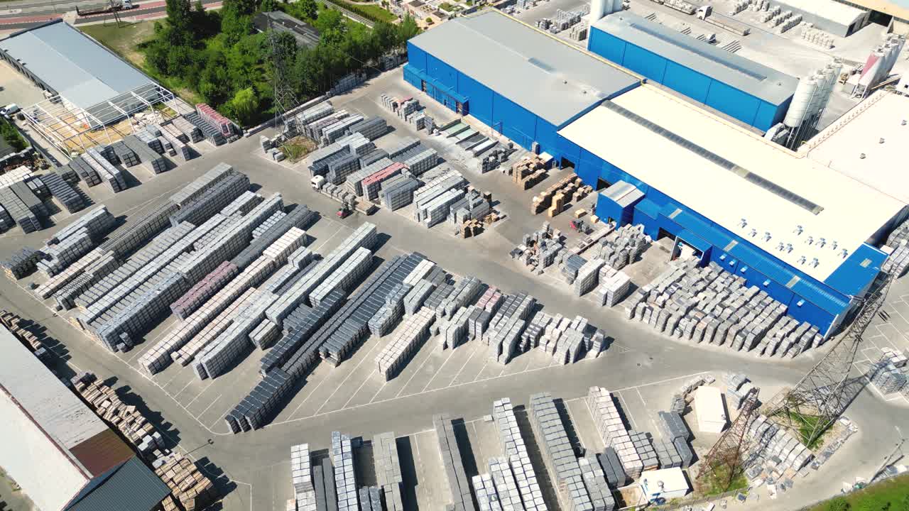 conductor de carretilla elevadora en almacén conduciendo entre filas de estanterías con pilas de cajas y materiales de embalaje