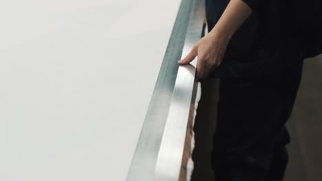 close-up of female hands drawing a line for cutting on fabric under a ruler at a textile factory