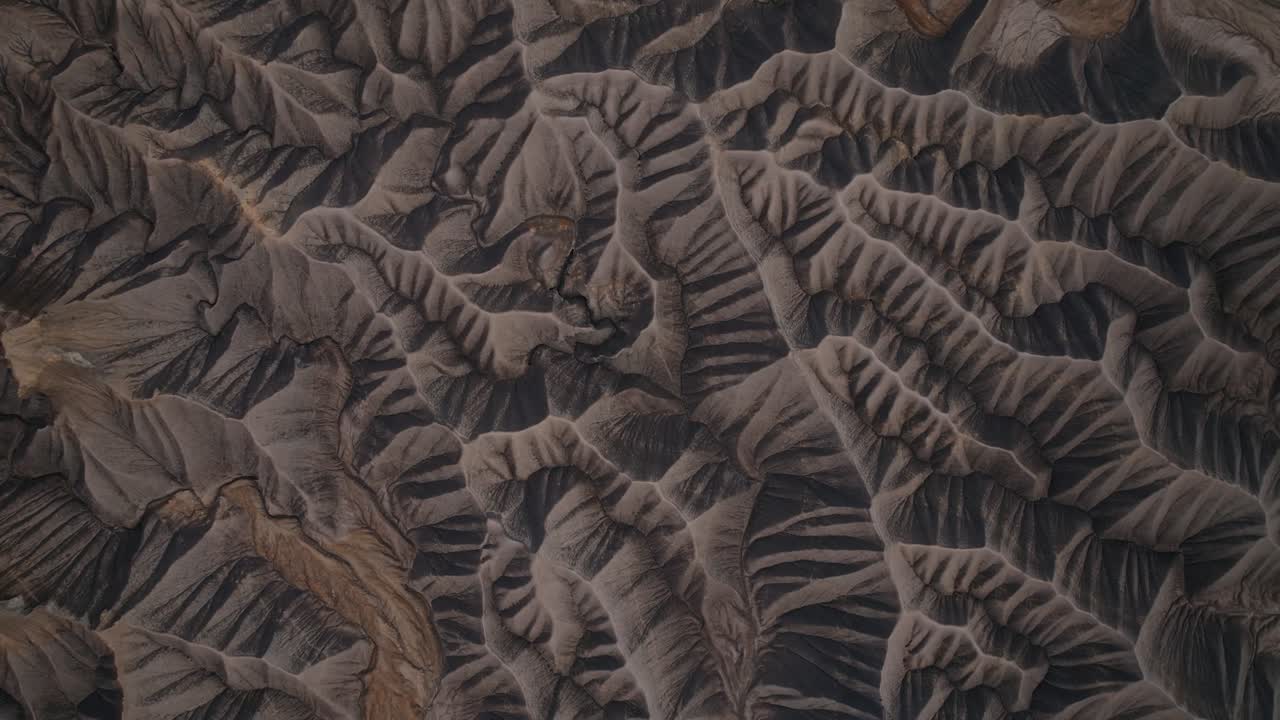 Deeply carved desert badlands ridges and erosion channels in Utah near Factory Butte, drone