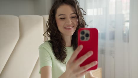 Brunette-woman-making-facetime-video-calling-with-smartphone-at-home