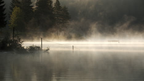 Unheimlicher-Nebel,-Der-Den-See-In-Der-Dämmerung-In-Der-Schweiz-Umgibt---Schwenk