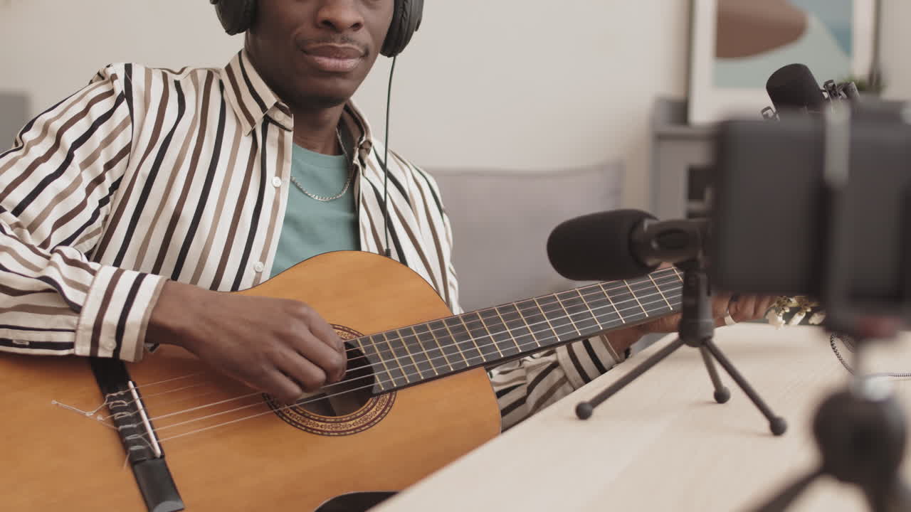 Man playing guitar and recording music