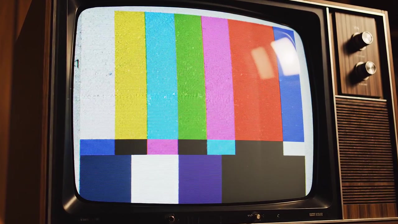 Televisor vintage con vetas de madera mostrando barras de color y ruido estático