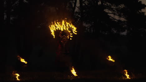 fire dancer performance in a dark forest
