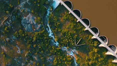 fotografía aérea de una larga presa con agua que fluye desde la puerta de inundación