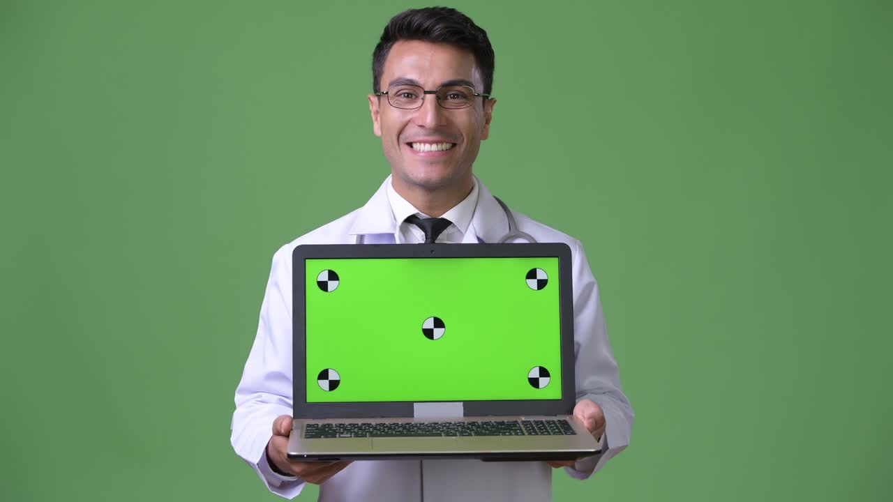 joven hombre hispano guapo médico contra fondo verde