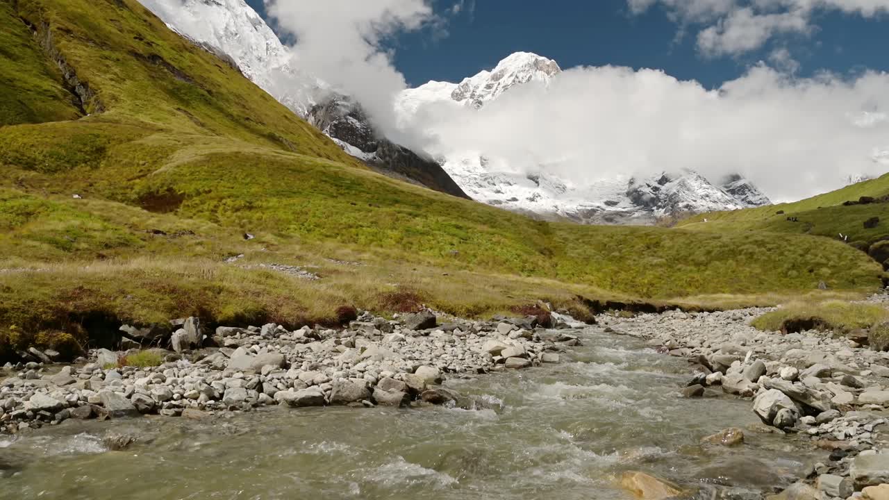 paisaje de río glacial y montañas cubiertas de nieve, nepal montaña río y paisaje de arroyo con agua corriente y montañas del himalaya en el cielo azul día soleado mientras trekking en nepal