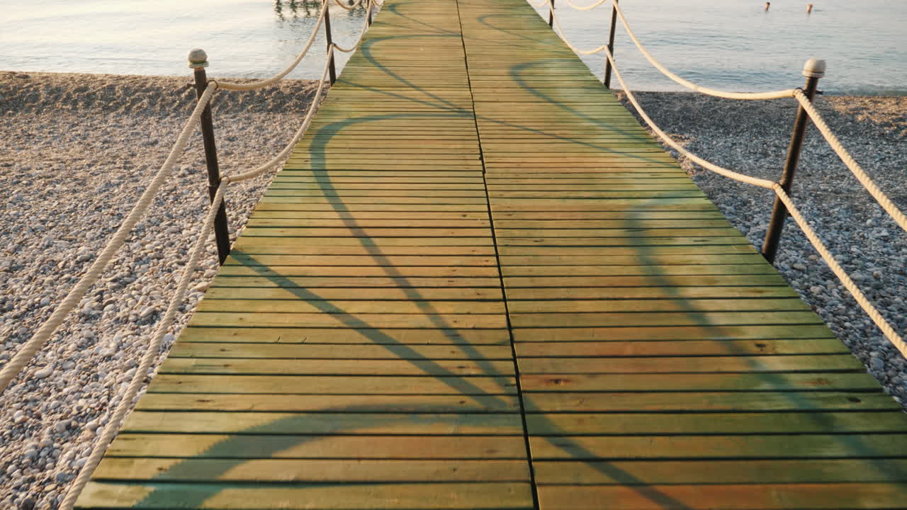 camine sobre un muelle de madera hasta el mar, una vista en primera persona de una toma de steadicam
