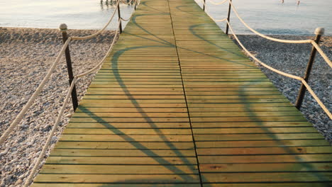 camine sobre un muelle de madera hasta el mar, una vista en primera persona de una toma de steadicam