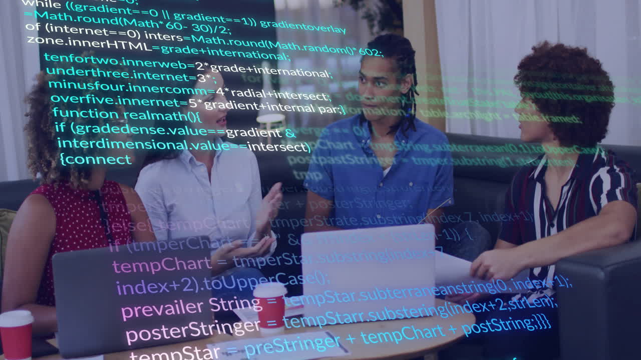 Four coworkers sitting around low office table using silver laptop, showing floating code overlays