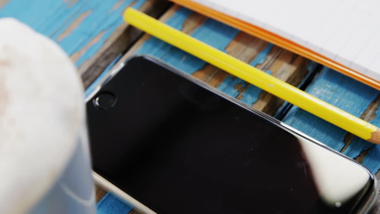 teléfono inteligente, lápiz y taza de café