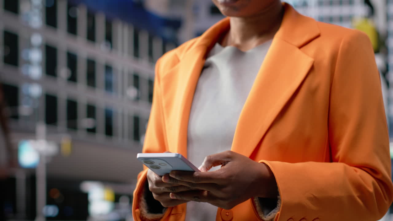 Portrait of businesswoman walking with phone in hand along business district