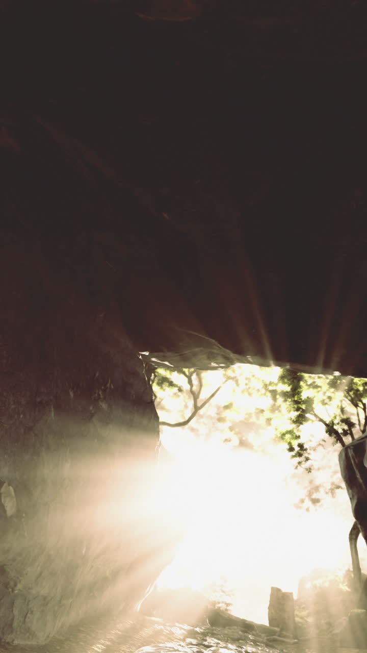 A luz atravessa a abertura de uma caverna, iluminando o ambiente rochoso