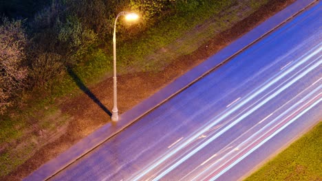 night traffic of passing cars on the road in the light of lanterns, timelapse