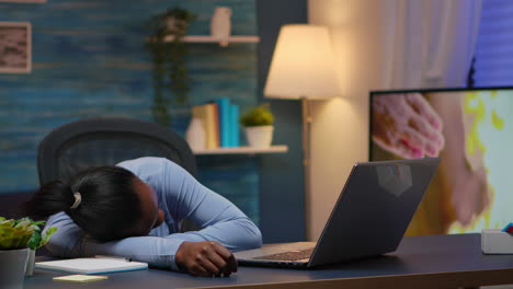 exhausted black businesswoman falling asleep on desk