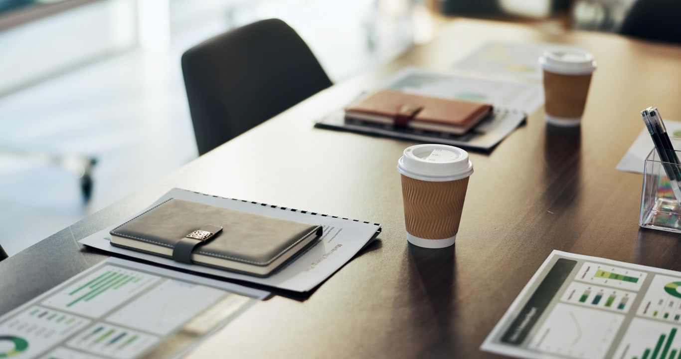 Empty Conference Table With Coffee Cups and Business Reports