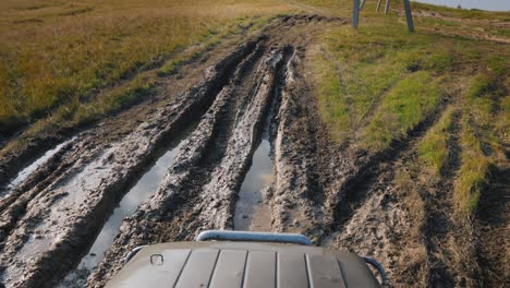 driving on an extremely bad dirt road with puddles. suv rides in the countryside