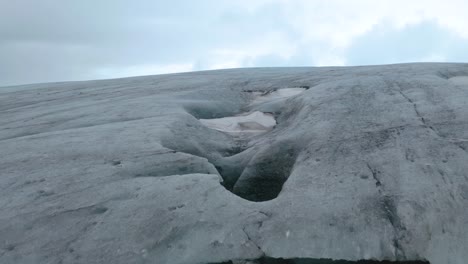 Aerial-Drone-flight-over-massive-Ice-Cave-during-cloudy-day-in-Iceland