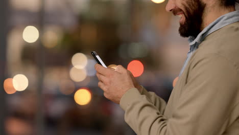 manos escribiendo mensajes en el teléfono en una ciudad concurrida